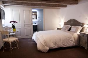 圣伊波利特Chambre Le Hupsa Pfannala的卧室配有一张白色的大床和一张桌子