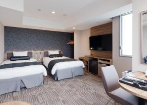 东京KEIKYU EX INN Haneda的酒店客房设有两张床和一台平面电视。