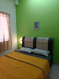 居銮HOMESTAY D'TEPIAN CASA, BANDAR SERI IMPIAN KLUANG的一间卧室设有一张带绿色墙壁的大床