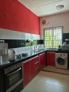 居銮HOMESTAY D'TEPIAN CASA, BANDAR SERI IMPIAN KLUANG的一间带红色橱柜和洗衣机的厨房