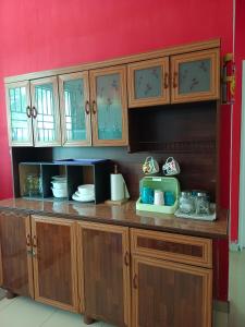 居銮HOMESTAY D'TEPIAN CASA, BANDAR SERI IMPIAN KLUANG的一间带木制橱柜和微波炉的厨房