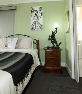 奥尔巴尼Kinsellas Water Views的一间卧室配有一张床,梳妆台上配有一盏灯