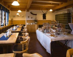 Rednitzhembach赫姆巴切尔豪弗酒店的餐厅配有长桌子和白色的桌椅