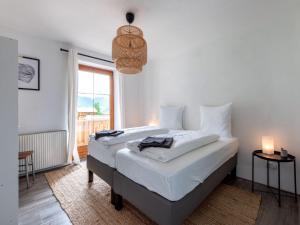 圣安东阿尔贝格Holiday home near St Anton am Arlberg with sauna的一间卧室配有一张带白色床单的床和一扇窗户。