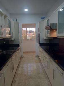 赫尔格达new marina heart of Hurghada的一间大厨房,配有白色橱柜和黑色台面