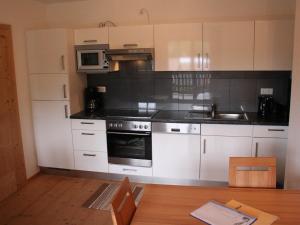 平茨高谷地霍勒尔斯巴赫Apartment with Sauna near Ski Slopes in Mittersill的厨房配有白色橱柜和炉灶烤箱。