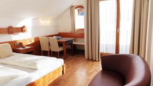 魏森湖Ferienwohnungen Plattner的配有床、椅子和桌子的酒店客房