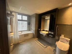 高雄碧港良居商旅-站前馆 的带浴缸、盥洗盆和卫生间的浴室