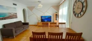 苏昂博Casa MALIBU的客厅配有沙发和墙上的时钟