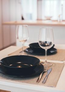 斯伽尔达Ring Stop Holiday Apartment的一张桌子,上面放着两杯葡萄酒,盘子和刀子