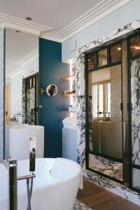 波尔多Hôtel Singulier Bordeaux的浴室配有白色浴缸和大镜子