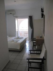 迈洛波塔斯马科斯海滩酒店的一间卧室配有一张床、一张桌子和一个窗户。