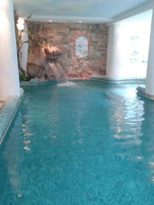 莫尔韦诺阿尔卑斯酒店的一座大楼内带水滑梯的游泳池
