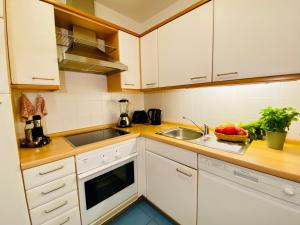 赛巴特班森Seeschloss "Meerblick"的厨房配有白色橱柜和水槽