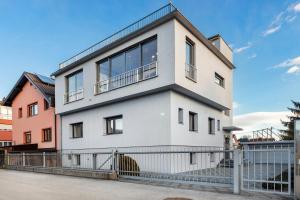 马里博尔Contemporary apartment with rooftop terrace in Maribor的前面有栅栏的白色房子