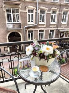 圣彼得堡Anabel at Nevsky 88的阳台上的桌子上放着咖啡和鲜花