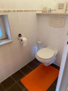 Sint-Genesius-Rodenarcisses的浴室铺有黑色瓷砖地板,设有白色卫生间。