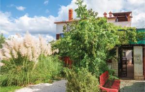 法扎纳Pet Friendly Apartment In Fazana With Wifi的花园中设有红色长椅的房子