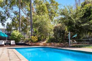 达博达博国际品质酒店的一座树木繁茂的庭院内的游泳池