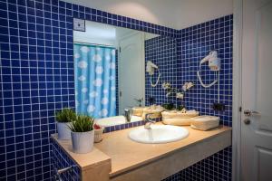 波多黎各米拉多马尔别墅酒店的蓝色瓷砖浴室设有水槽和镜子