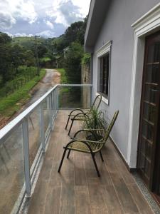 塞拉内格拉tranquilidade的阳台上配有两把椅子,享有道路美景