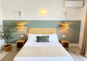 卡拉恩波特Club Menorca - Solo Adultos的一间卧室配有一张大床和两盏灯