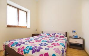 BičićiLovely Home In Barban With Kitchen的一间卧室配有一张带花卉床罩的床