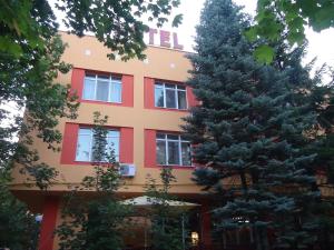 鲁塞法米莉亚家庭酒店的前面有两棵树的建筑