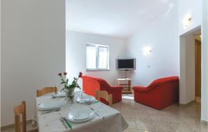 普拉小孔公寓1号的客厅配有桌子和红色椅子