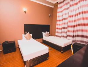 阿鲁沙Panone Hotels - Sakina的带两张床和窗帘的房间