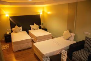 阿鲁沙Panone Hotels - Sakina的酒店客房,设有两张床和一张沙发