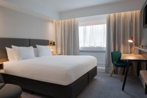 博尔顿假日博尔顿中心酒店的配有一张床和一张书桌的酒店客房