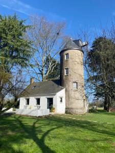 奥尔沃Le moulin de La Retardière的草场上一座有塔的老房子