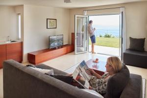 圣玛格丽塔-利古雷Il Leccio - Luxury Resort Portofino Monte的坐在沙发上读书的女人