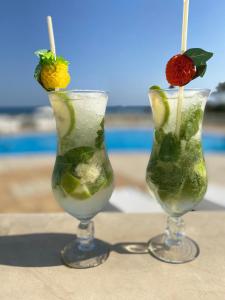 古莱比耶Cap Bon Kelibia Beach Hotel & Spa的两个马提尼酒,水果放在桌子上