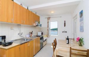 格鲁达格鲁达一卧室公寓的厨房配有木制橱柜、餐桌和用餐室