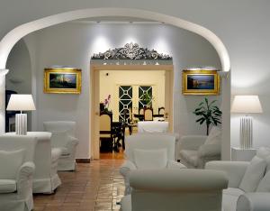 米诺利罗马纳别墅Spa酒店的一间设有白色椅子和桌子的等候室