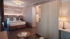 威尼斯Hotel Aquarius Venice-Ascend Hotel Collection的酒店客房配有一张床铺和一张桌子。