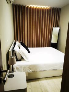 罗安达Apartamento com Vista para a Baía de Luanda的卧室配有白色的床和窗户