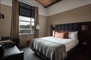 邓迪Hotel Indigo - Dundee, an IHG Hotel的一间卧室设有一张大床和一个窗户。