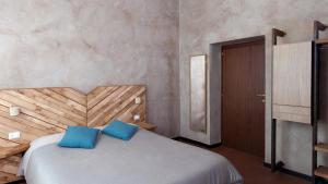 罗马Folia的一间卧室配有一张带两个蓝色枕头的床