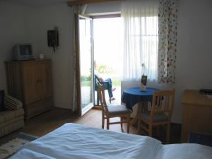 施泰格斯巴赫兰德埃德酒店的卧室配有一张床和一张桌子及椅子