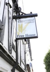 亚瑟斯通The Wheatsheaf Inn的建筑物一侧的树屋标志