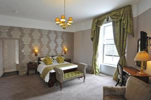 瓦伊河畔罗斯Royal Hotel by Greene King Inns的一间卧室配有一张床、一张沙发和一个窗口