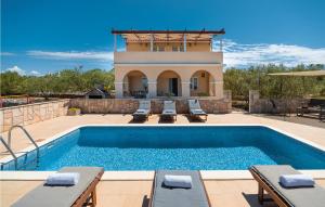 尼亚卢卡Cozy Home In Vela Luka With Outdoor Swimming Pool的一个带椅子的游泳池以及一座房子