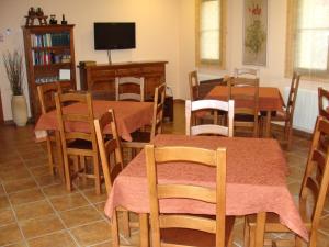 圣胡安德奥尔特加Alojamiento Rural La Henera的一间带桌椅和电视的用餐室