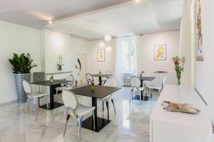Cénac-et-Saint-Julien马拉瓦尔城堡旅馆的用餐室配有黑桌和白色椅子