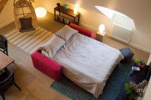 勒帕莱Les Appartements d'Alexandre的一间卧室配有一张床和一张红色的沙发