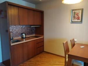 查克维Sea View Apartment at Oasis Dreamland Resort的厨房配有木制橱柜、桌子和桌子以及用餐室。