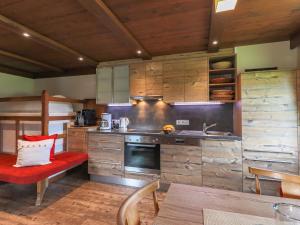 米特西尔Rustic country house in Mittersill near ski area的一间厨房,内设木制橱柜和红色长凳